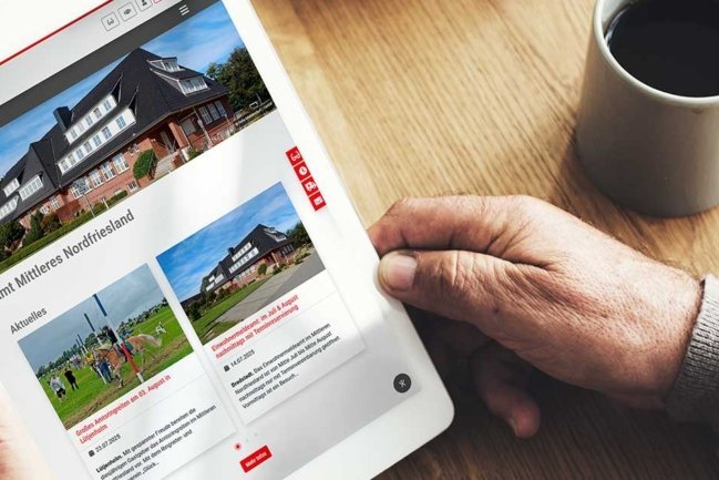 Ein Mann betrachtet die Amtsseite Amt Mittleres Nordfriesland auf seinem Tablet